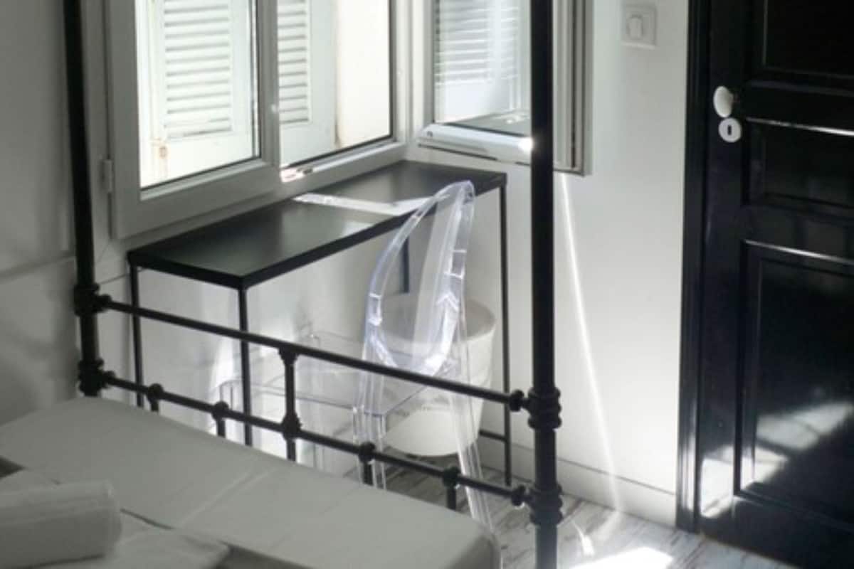 A room with a bed, a desk, and a chair.