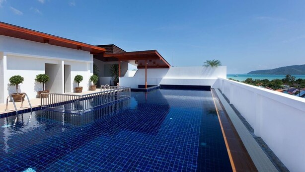 A rooftop infinity pool with a clear view of the ocean and distant hills. - Rawai Princess Hotel (Rawai)