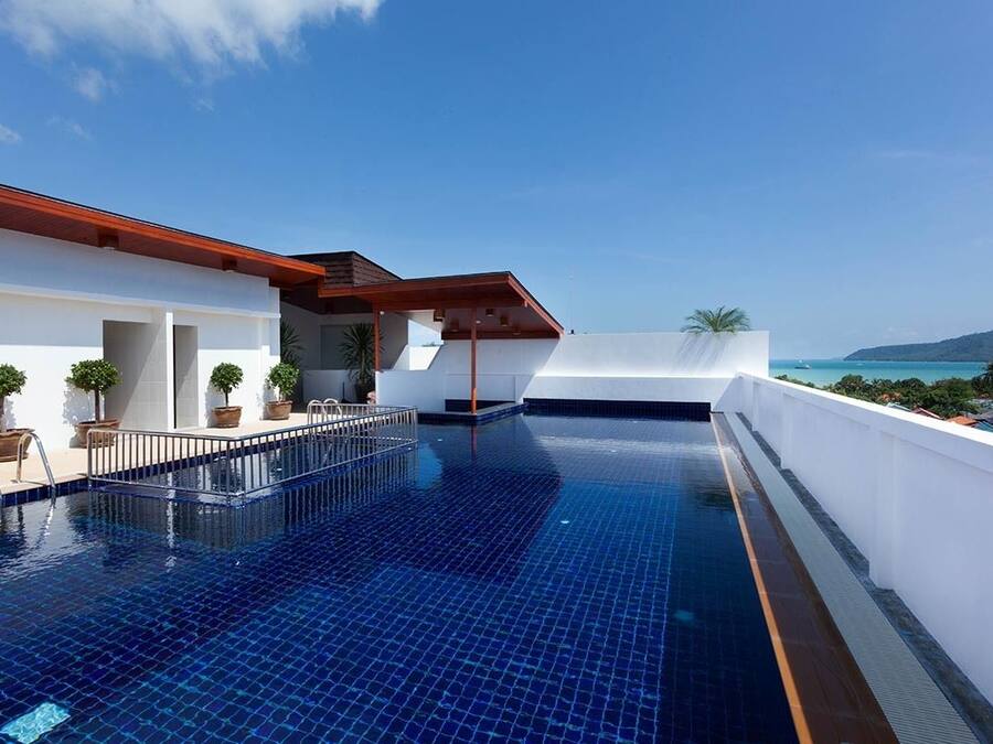 Una piscina al aire libre, sillones reclinables de piscina