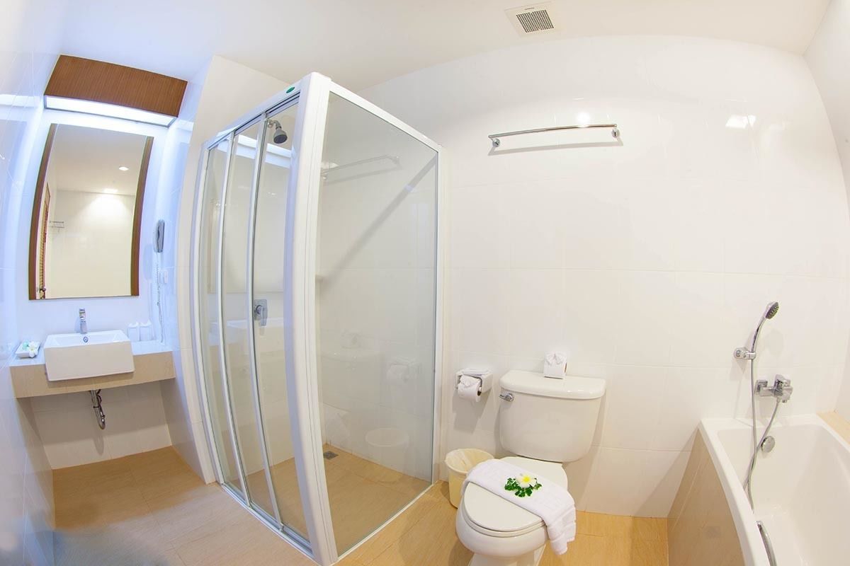 Un baño moderno con ducha de mampara de vidrio, inodoro y bañera.