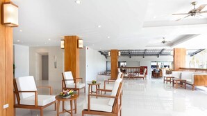 A spacious lobby with wooden furniture and a high ceiling. - Rawai Princess Hotel (Rawai)