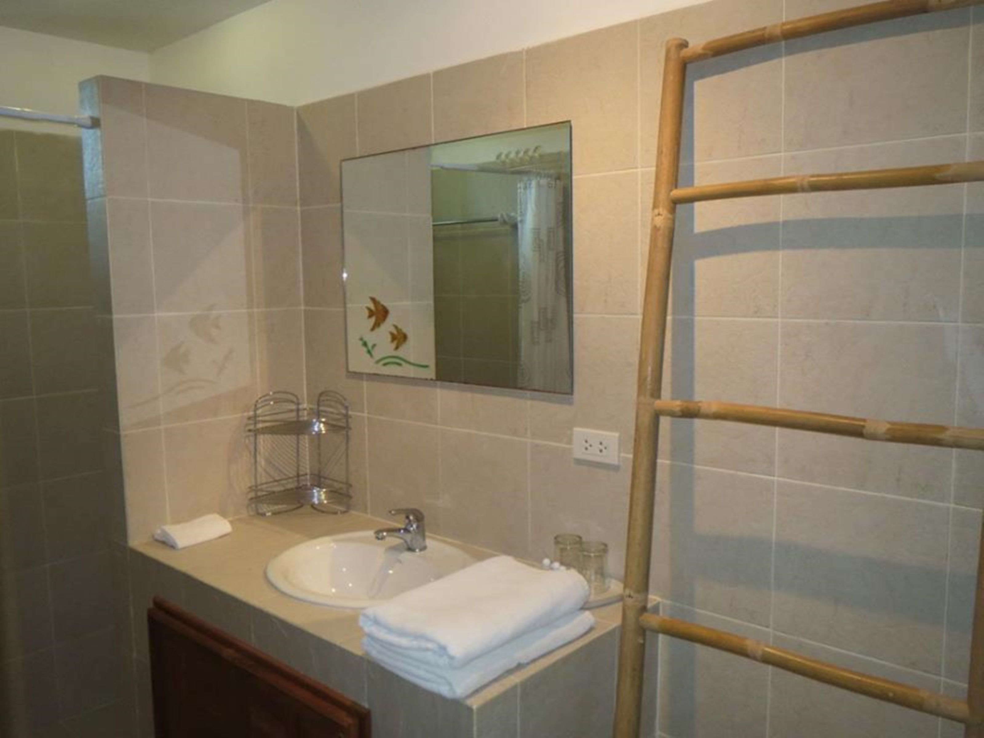 A bathroom with a sink, mirror, and towel rack.