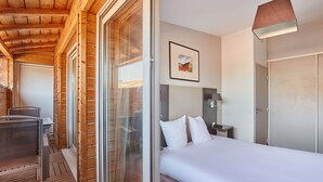 A hotel room with a bed, a desk, a chair, a window, and a door. - Odalys City Apartment Hotel - Toulouse Centre Gare (Toulouse)