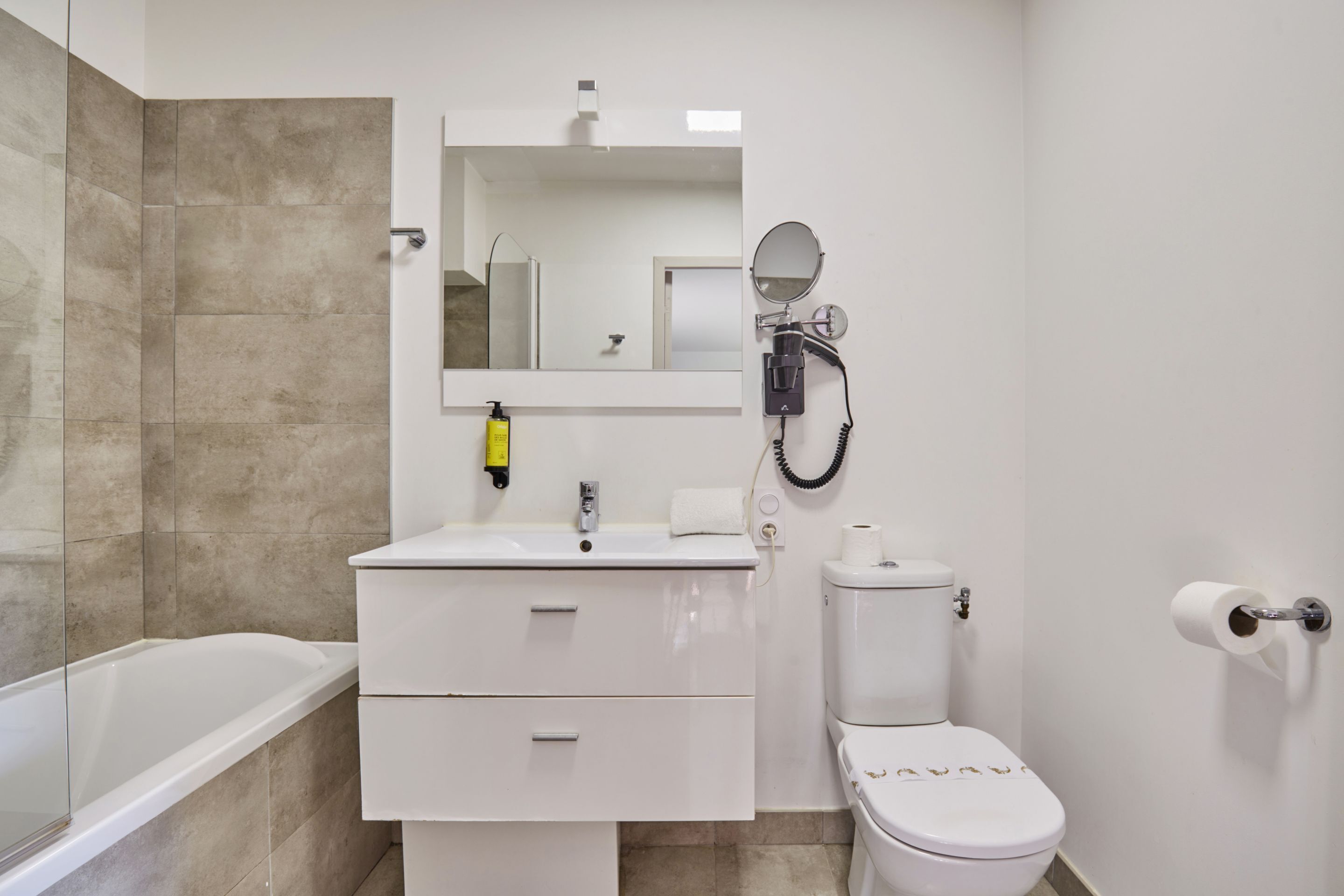 Une salle de bain avec une baignoire, un lavabo, des toilettes et un miroir.