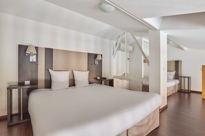 A modern hotel room with a large bed, two bedside tables, a ceiling light, and a window. - Odalys City Apartment Hotel - Toulouse Centre Gare (Toulouse)