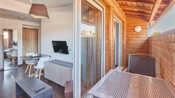 A modern interior with a dining area, a TV, and a wooden ceiling. - Odalys City Apartment Hotel - Toulouse Centre Gare (Toulouse)