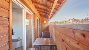 A wooden cabin with a balcony, a table, and a chair. - Odalys City Apartment Hotel - Toulouse Centre Gare (Toulouse)