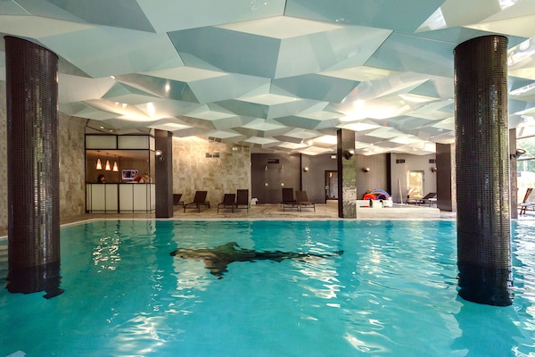 Una piscina techada, sillones reclinables de piscina