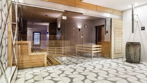 A modern hotel lobby with a geometric patterned floor, wooden reception desk, and a glass partition. - Diune Resort (Kolobrzeg)