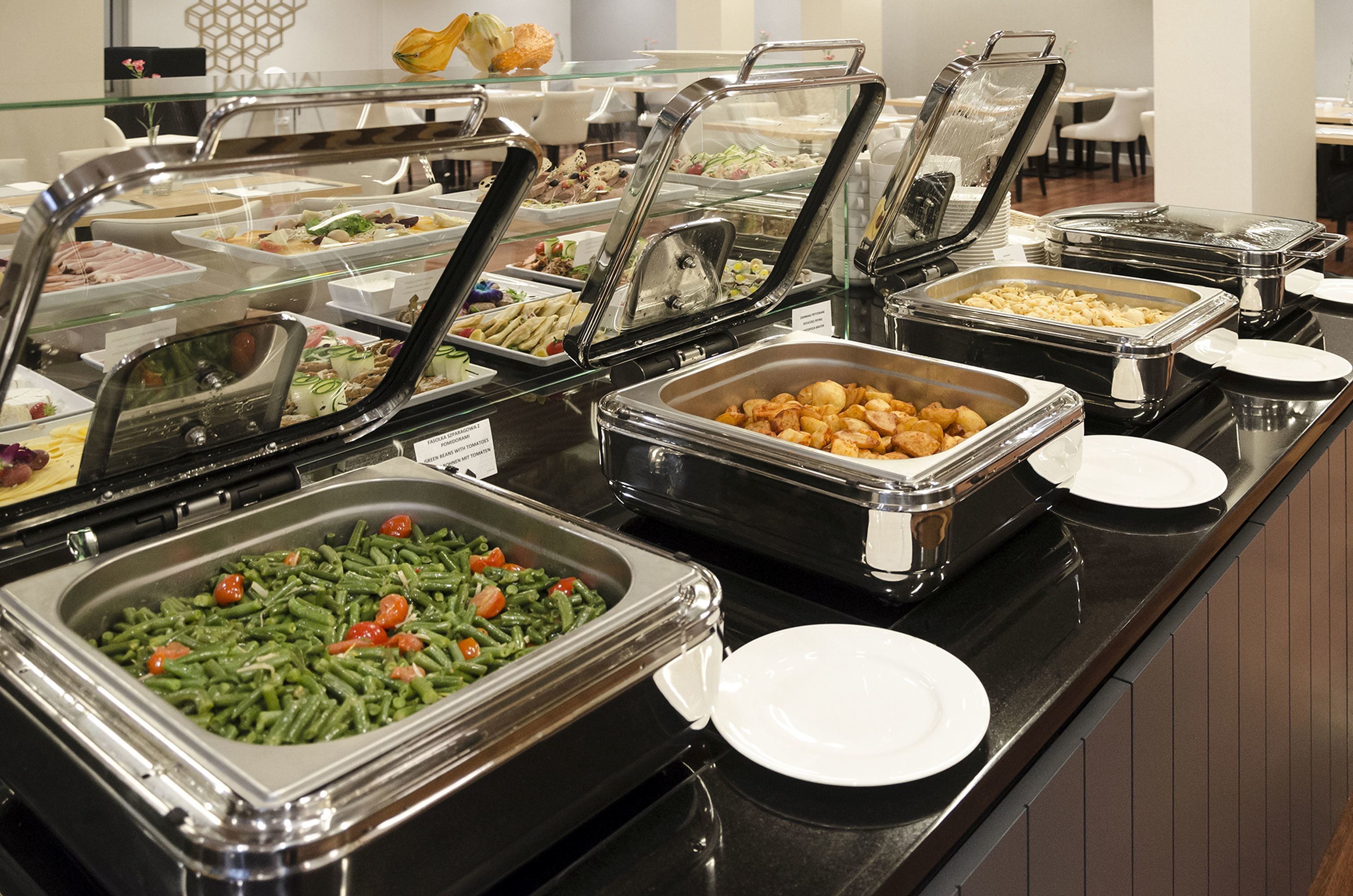 A buffet with various food options, including salads, meats, and vegetables.
