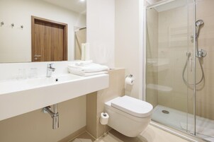 Ein modernes Badezimmer mit Waschbecken, Toilette und Duschkabine.
