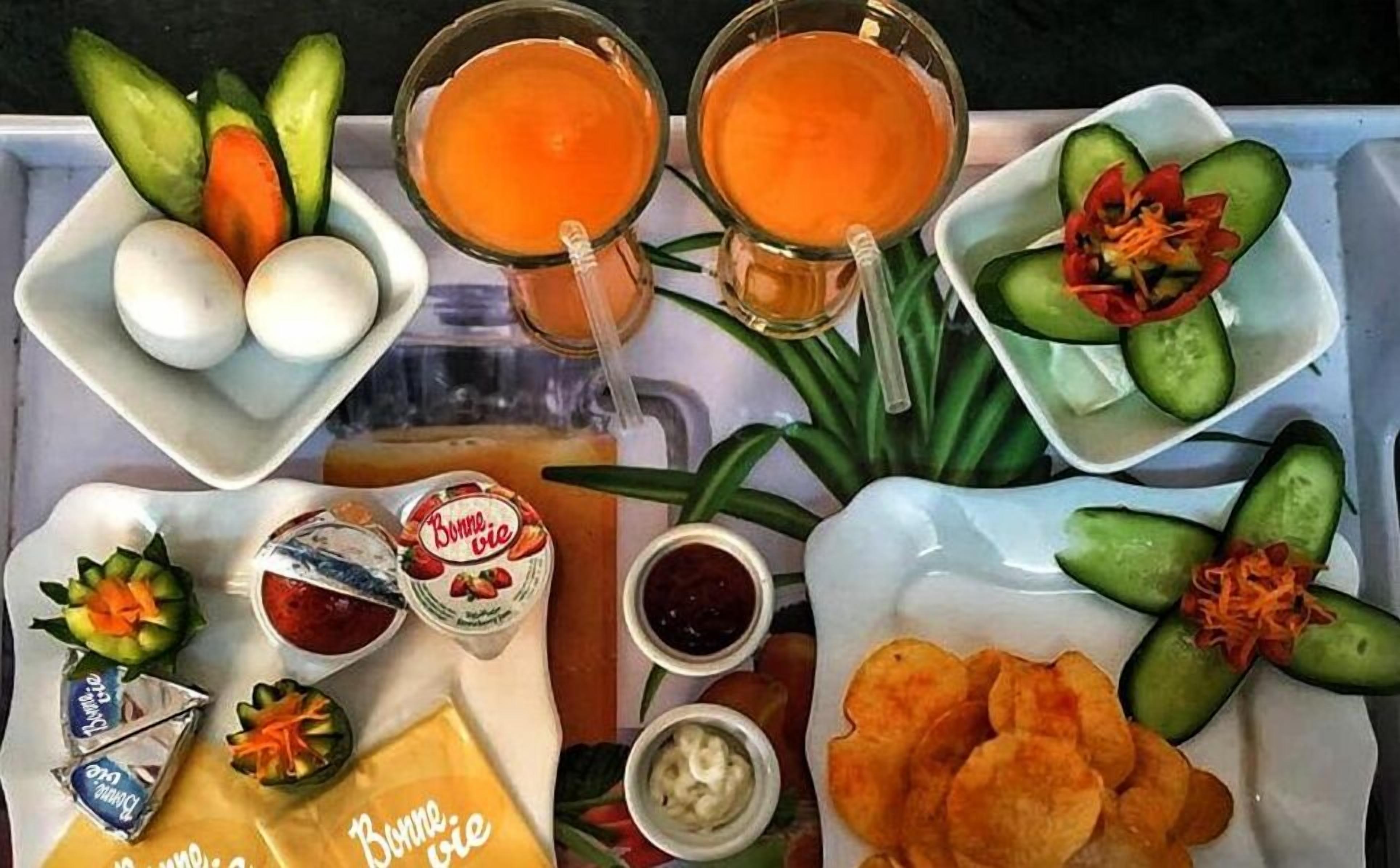 A tray with various food items including eggs, sliced cucumbers, carrots, and chips.