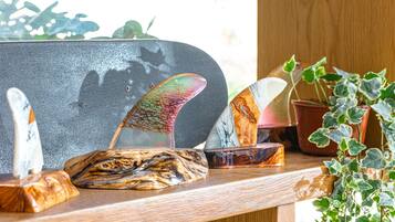 Una estantería de madera con objetos decorativos, incluyendo un monopatín, una cuchara y una planta.