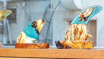Deux sculptures en bois ornées de touches de turquoise, posées sur une table en bois.
