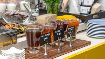 A beverage station with various drinks and a caution sign.
