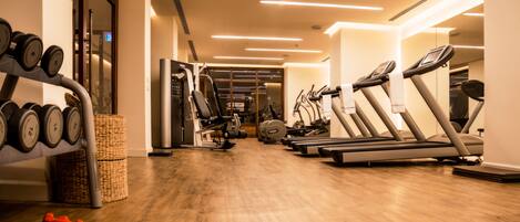 A gym with treadmills, elliptical machines, and free weights.