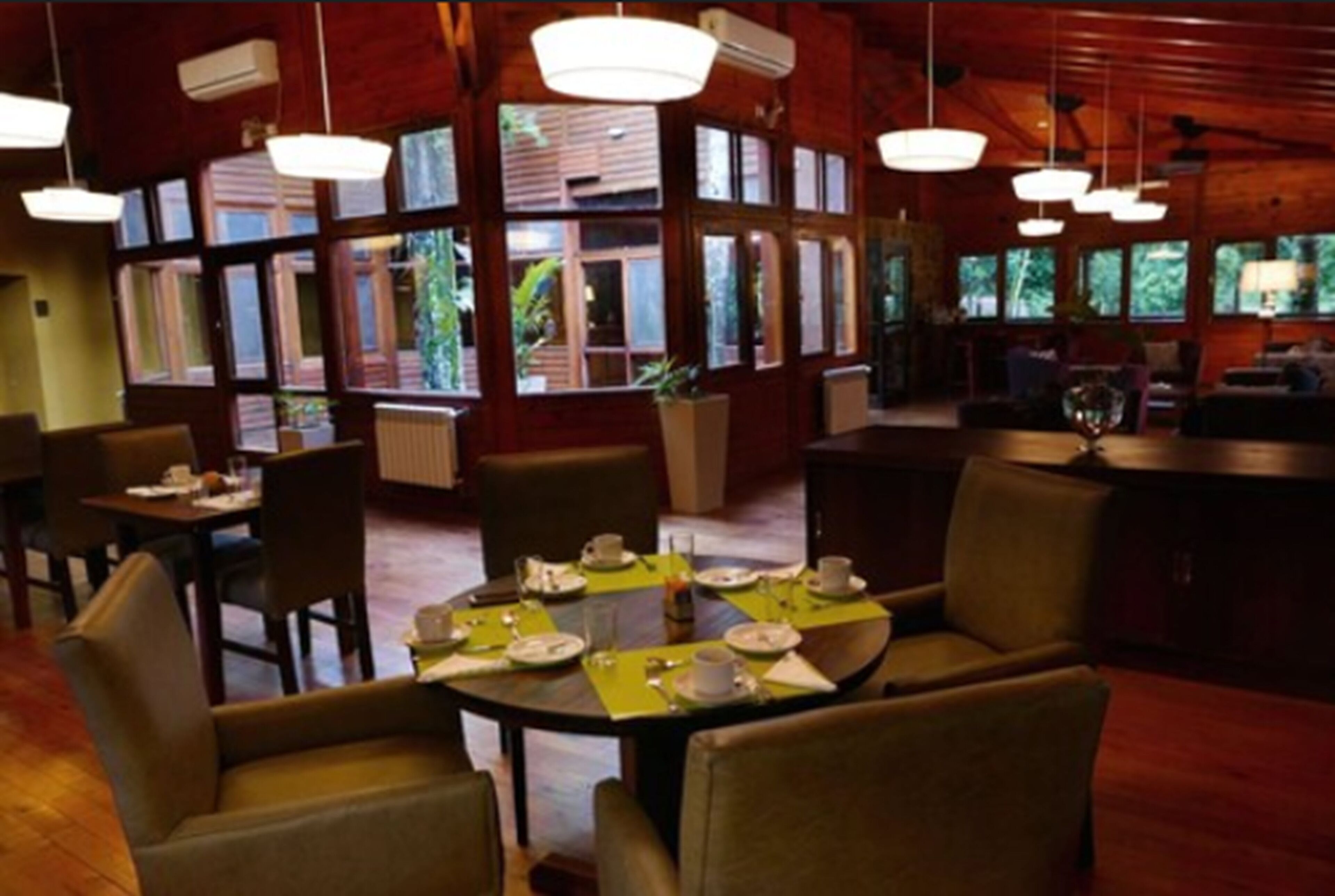 Un restaurant au décor intérieur en bois, avec des tables rondes et des chaises.