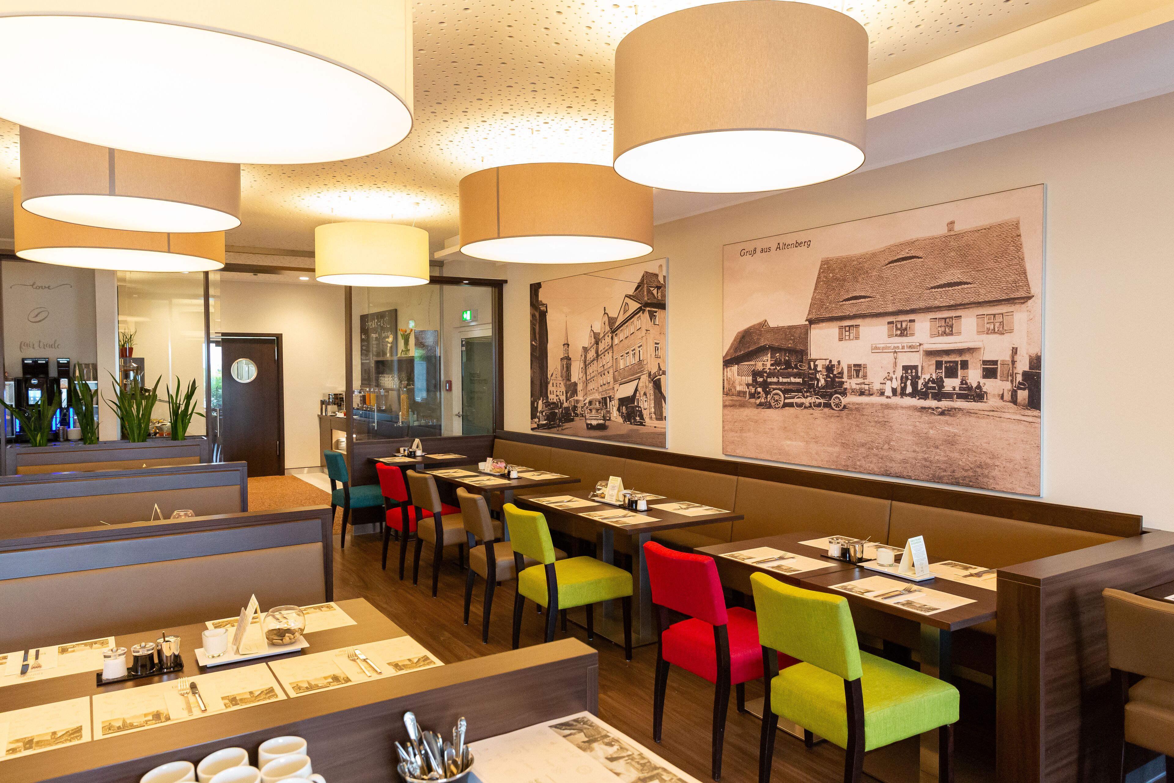 Um restaurante com cabines e mesas, com uma grande fotografia histórica na parede.