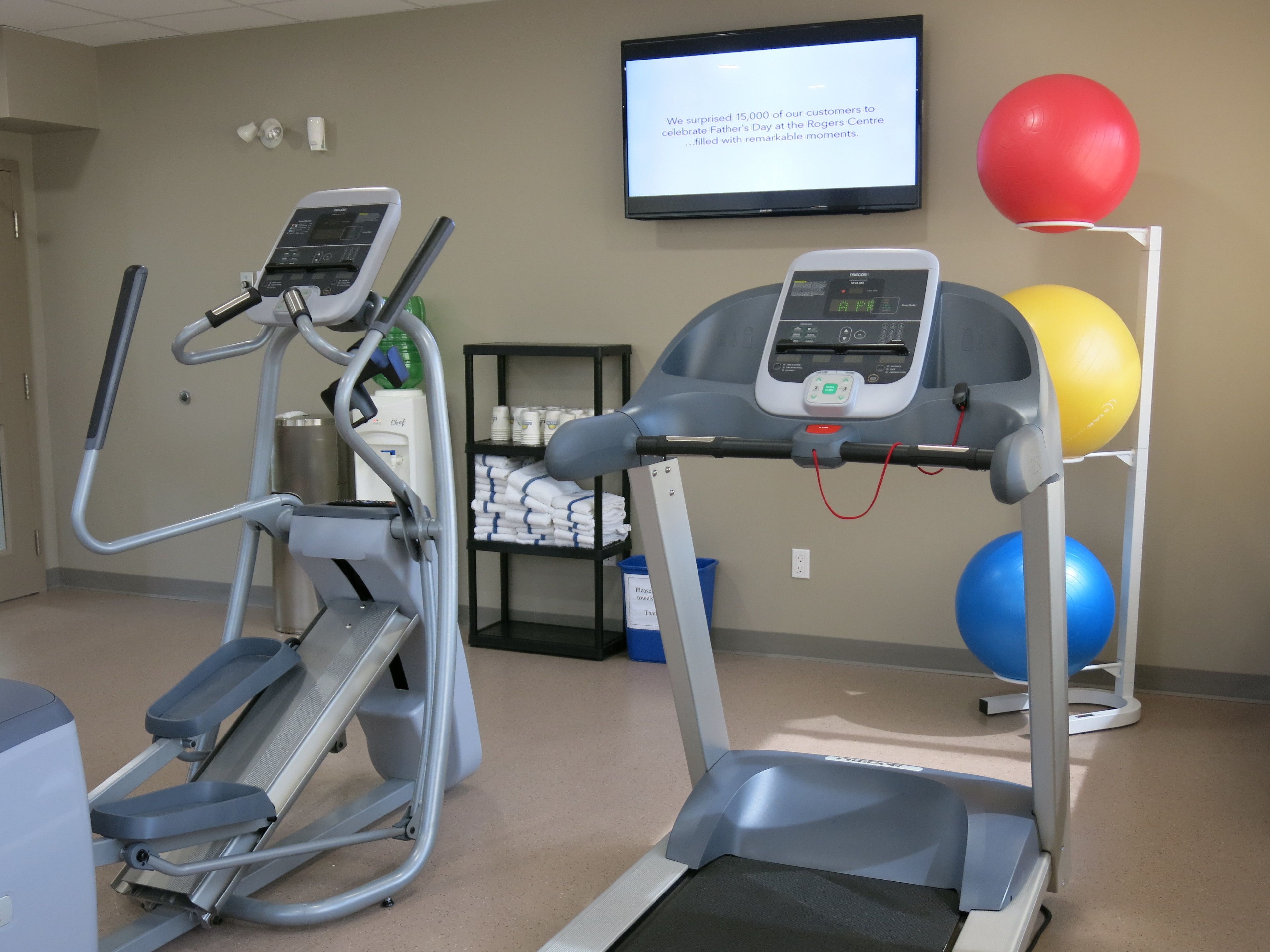 A fitness room with treadmills, a stationary bike, and exercise balls.