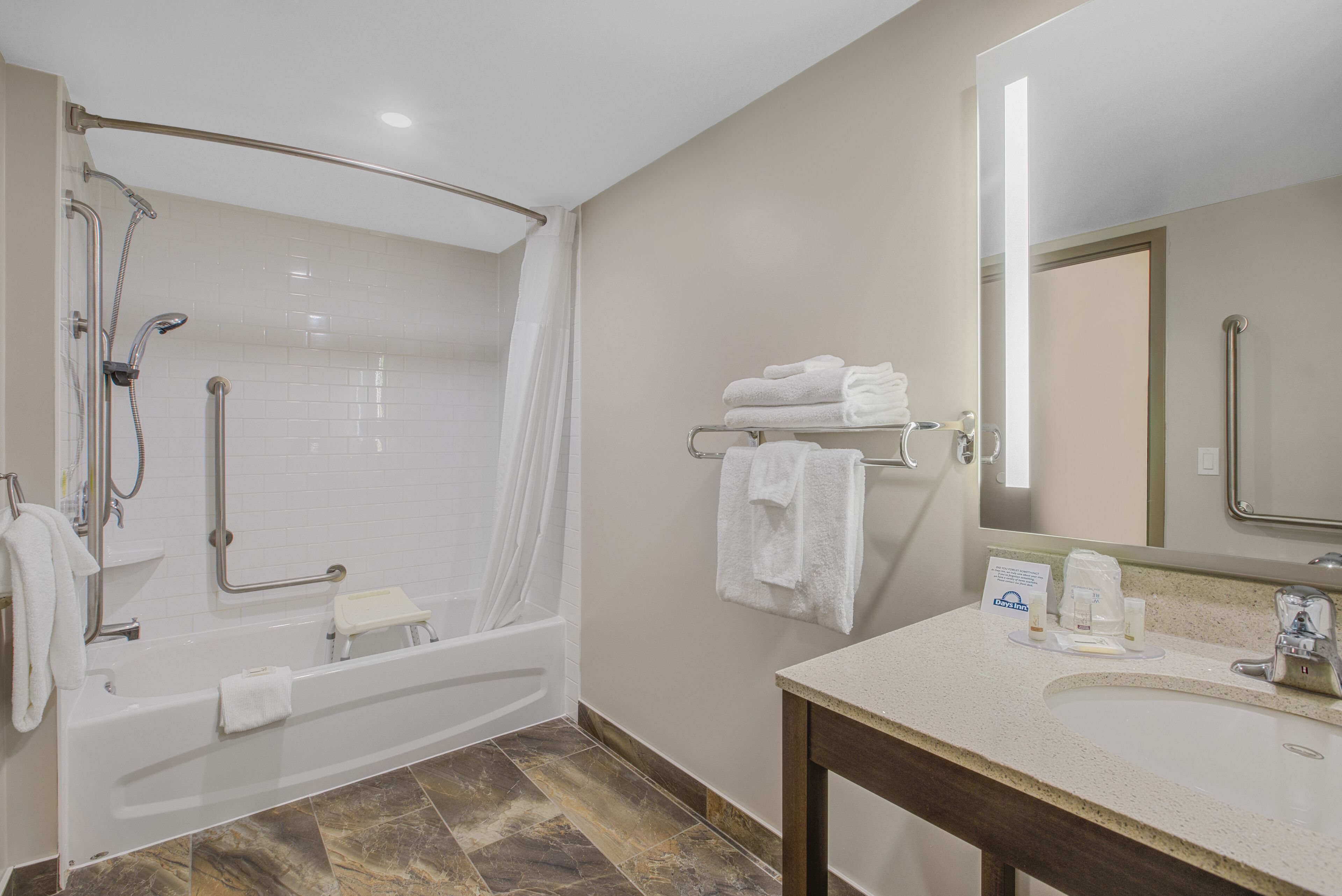 A modern bathroom with a walk-in shower, a bathtub, a vanity with a sink, and a mirror.