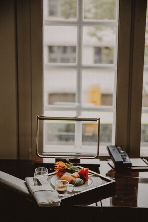 Mesa de jantar bem organizada com um prato de comida, um copo de bebida e um controle remoto.