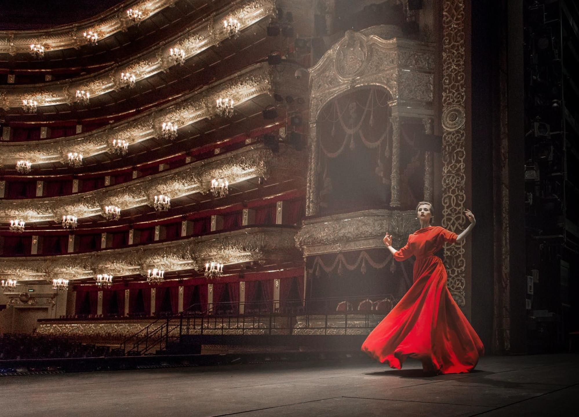 Un teatro imponente con varios balcones y columnas ricamente decoradas.