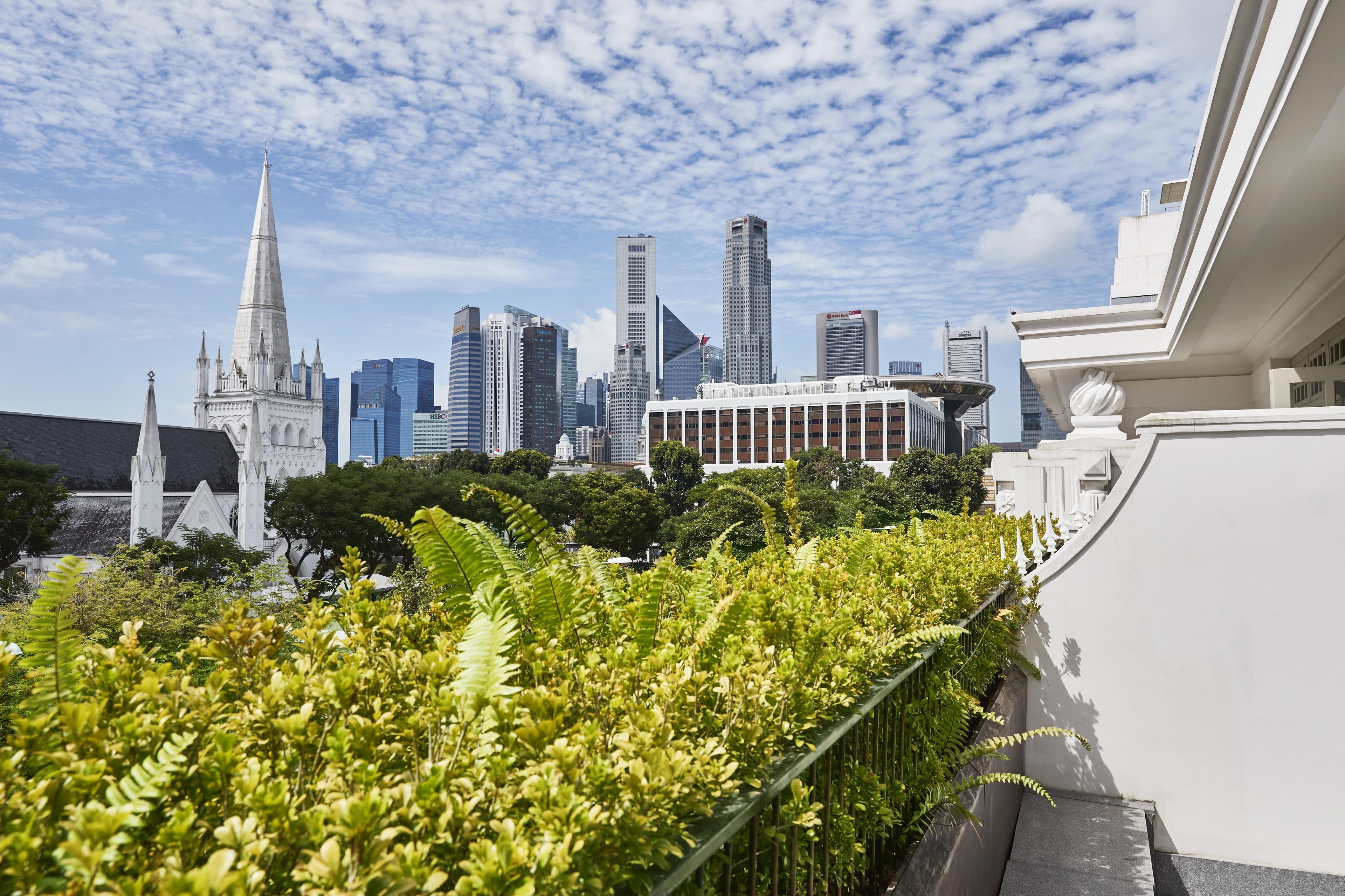 A city skyline with modern buildings and a historic church spire.