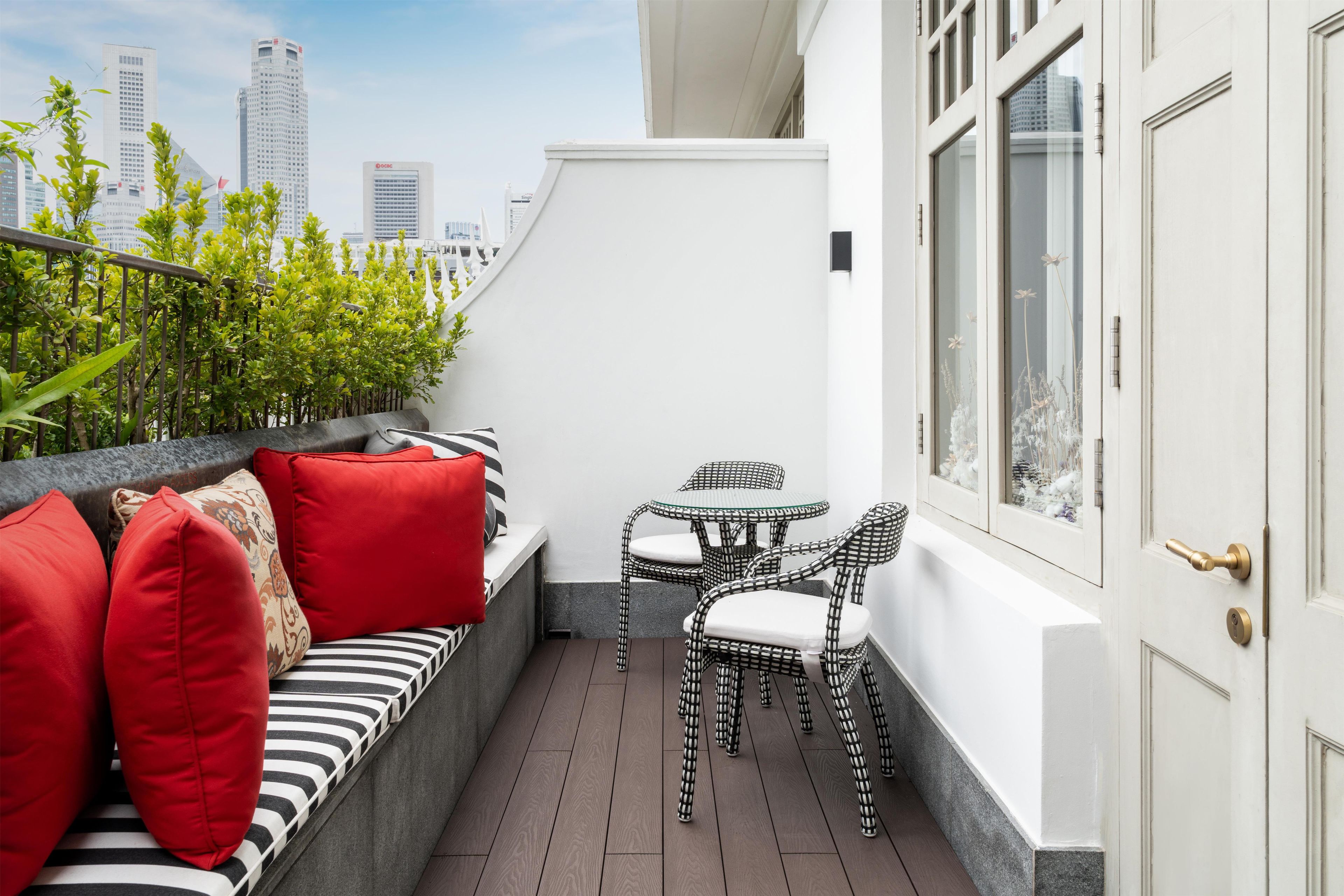 Un balcone con un divano, sedie e un tavolino.