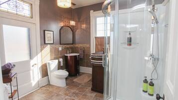 Un baño con inodoro, lavabo y ducha.