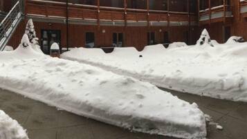 A snow-covered courtyard with a staircase leading to a building entrance.