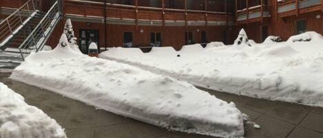 Un patio cubierto de nieve con una escalera que lleva a la entrada de un edificio.