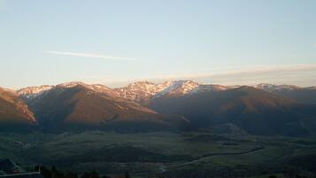A mountain landscape with a valley and a small settlement at the base.