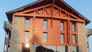 A multi-story building with a stone facade and wooden beams. - Apart-Hôtel Le Pic de l'Ours (Font-Romeu-Odeillo-Via)