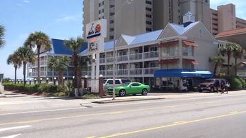 A hotel with a blue awning and a sign for 'Mystic Sea'.