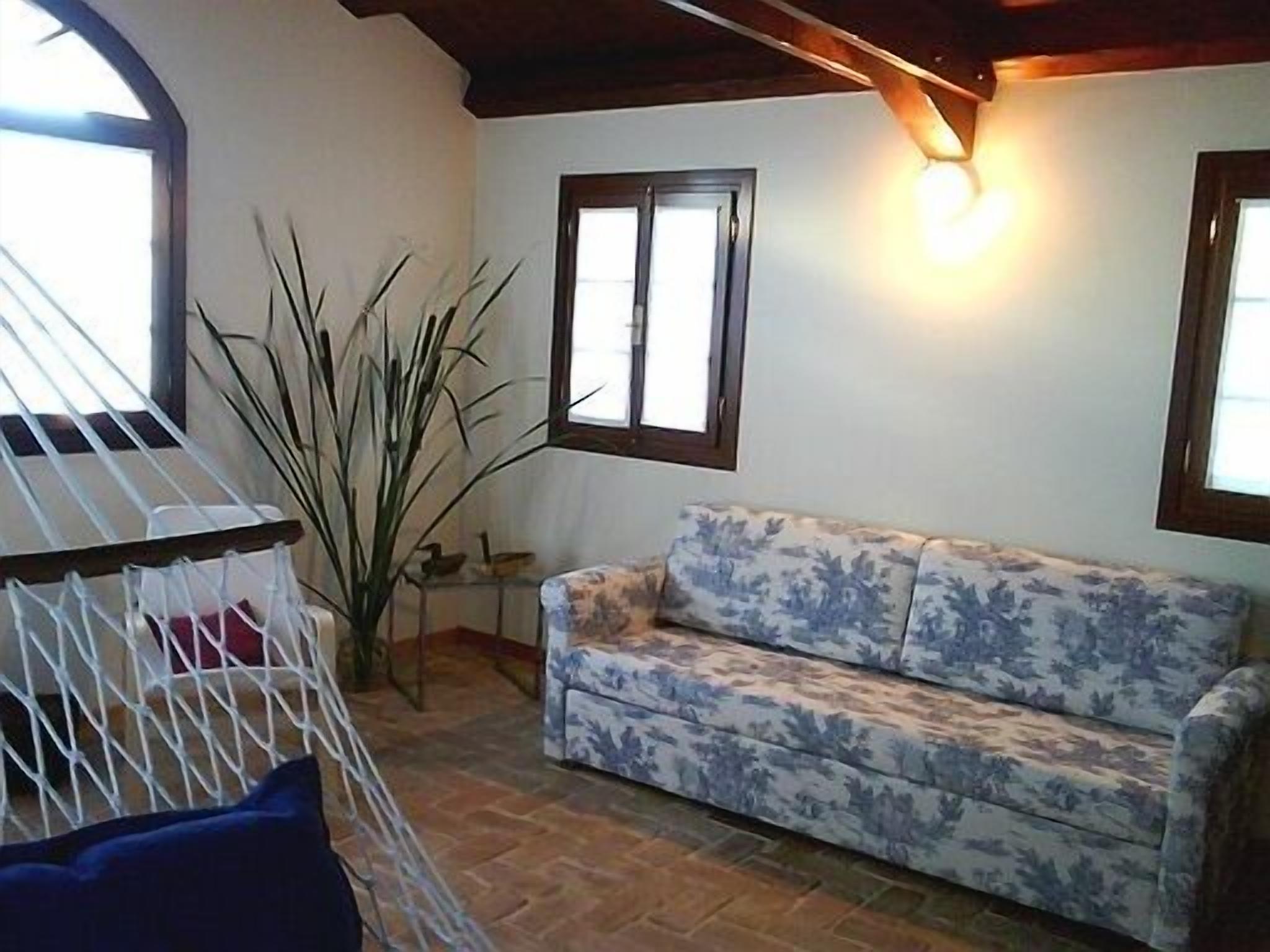 Une pièce avec un canapé, une petite table et une plante.