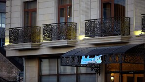 Een hotel met versierde balkons en een neonbord.
