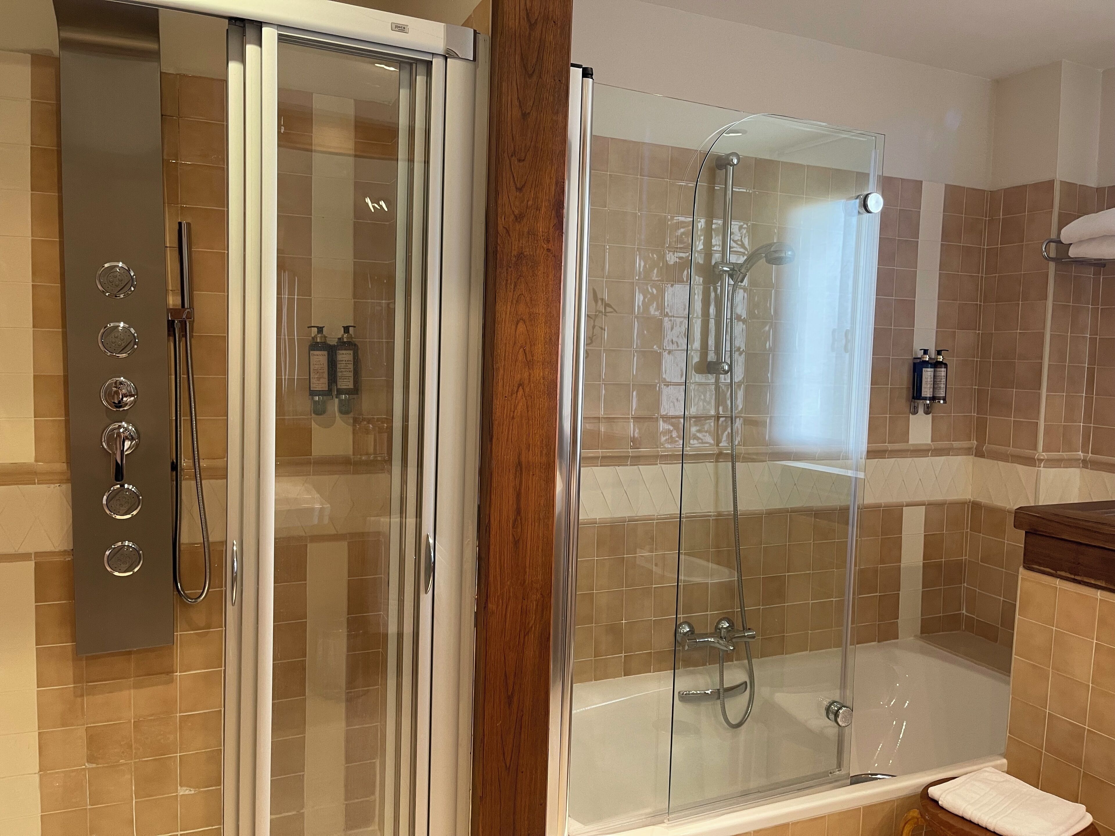 Une salle de bain moderne dotée d’une douche à parois de verre, d’une baignoire et de toilettes.