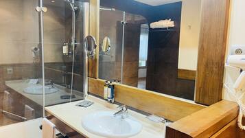 Un bagno moderno con doccia vetrata, lavabo bianco e specchio grande.