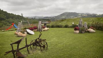 Escape to a serene outdoor oasis with a lush lawn, rustic garden elements, and a picturesque playground.