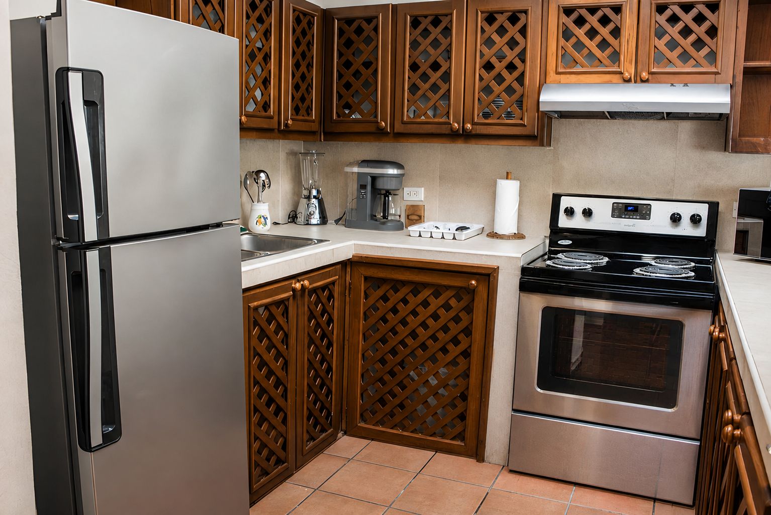 Una cocina con refrigerador, estufa, horno y armarios de madera.
