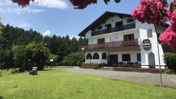 A two-story building with a balcony and a sign that reads "Hotel Bergblick Restaurant". - Hotel Bergblick (Pomerode)