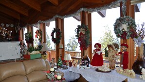 Una habitación acogedora con techo de madera, un sofá de cuero y una mesa decorada con adornos y figuritas navideñas.