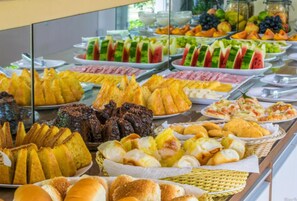 A buffet with various food items including fruits, pastries, and meats. - Pousada Recanto Jota Ge (Paraty)