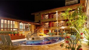 Un hôtel doté d’une piscine, d’un espace extérieur aménagé et d’un bâtiment à plusieurs étages avec des balcons.