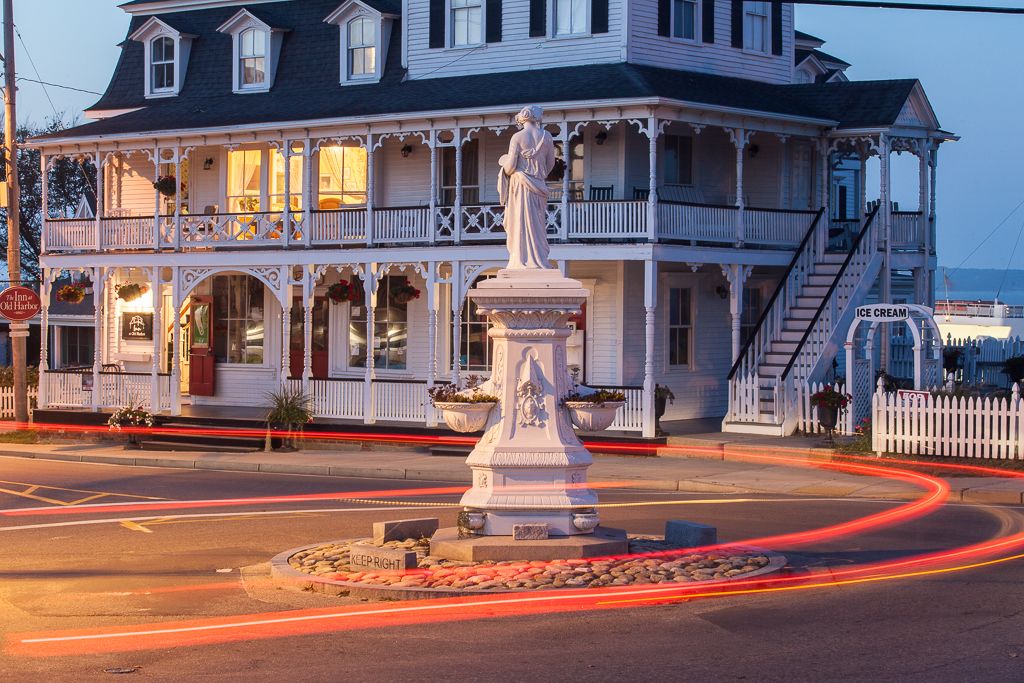 A historic building with a balcony, a statue in front, and a sign for 'Ice Cream'.