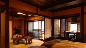 A traditional Japanese-style room with tatami flooring, a low wooden ceiling, and sliding doors leading to a balcony. - Lakeland Hotel Mizunosato (Fujikawaguchiko)