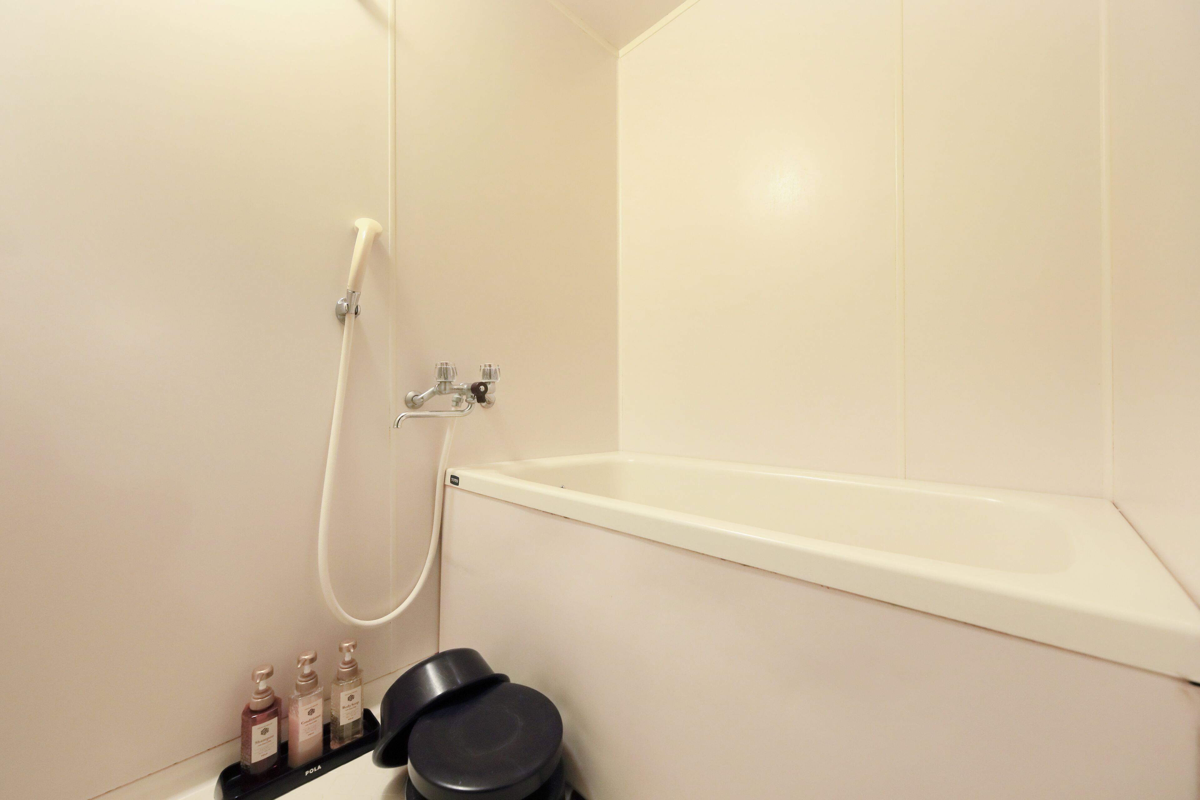 Ein Badezimmer mit einer Badewanne, einer Dusche und einem Ablagefach für Toilettenartikel.