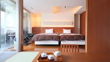 A hotel room with a bed, bedside table, and a tray with teapots.