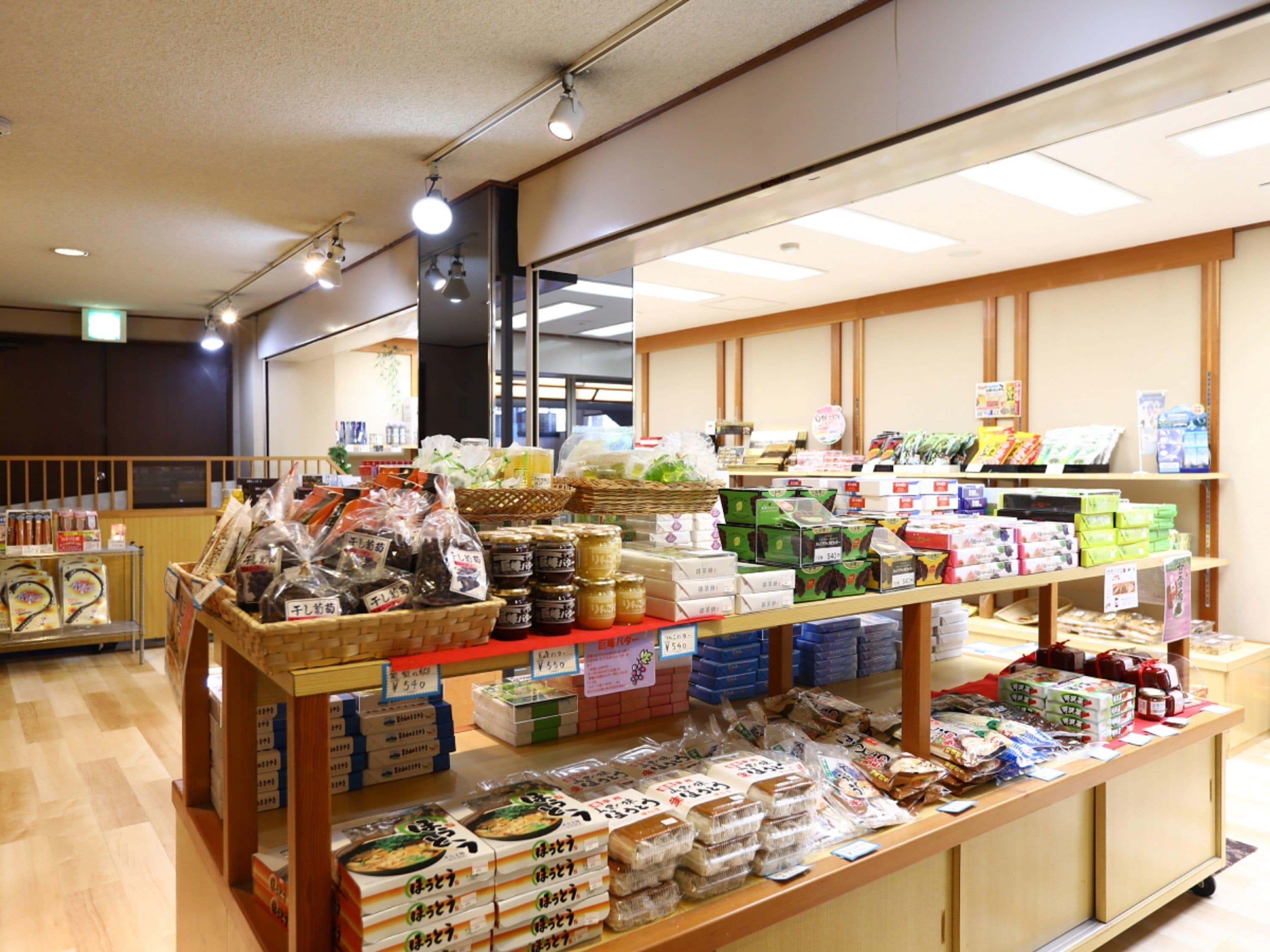 Interior de un supermercado con estantes llenos de diversos productos envasados, incluyendo alimentos y productos del hogar.