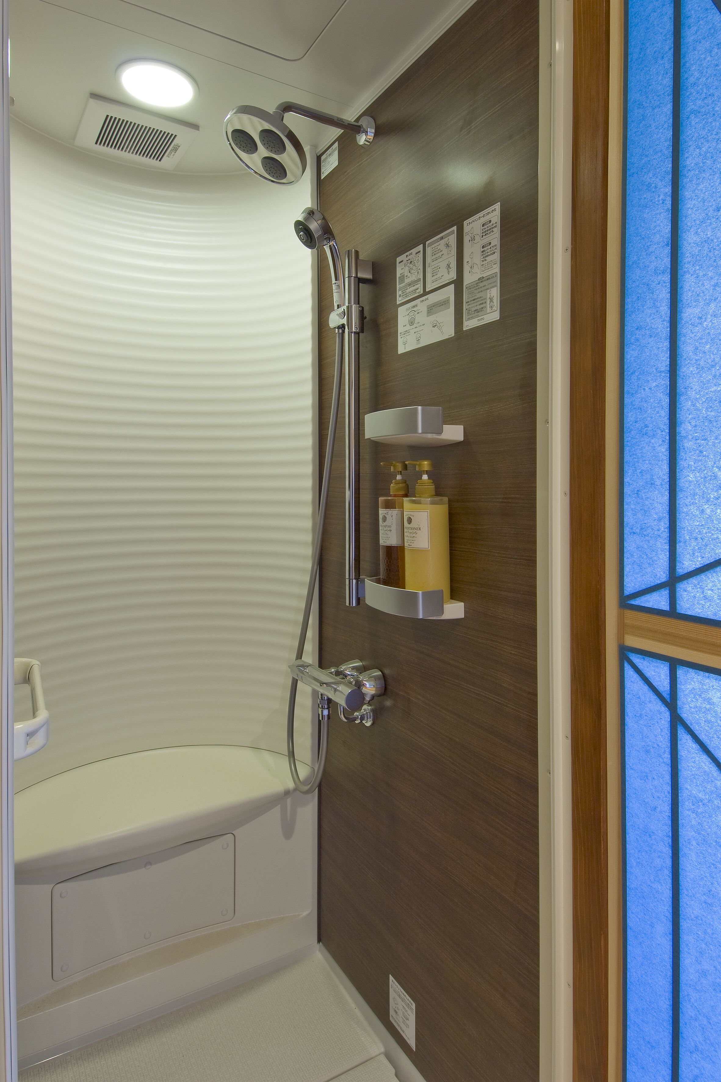 A modern bathroom with a shower, a toilet, and a vanity with shelves.